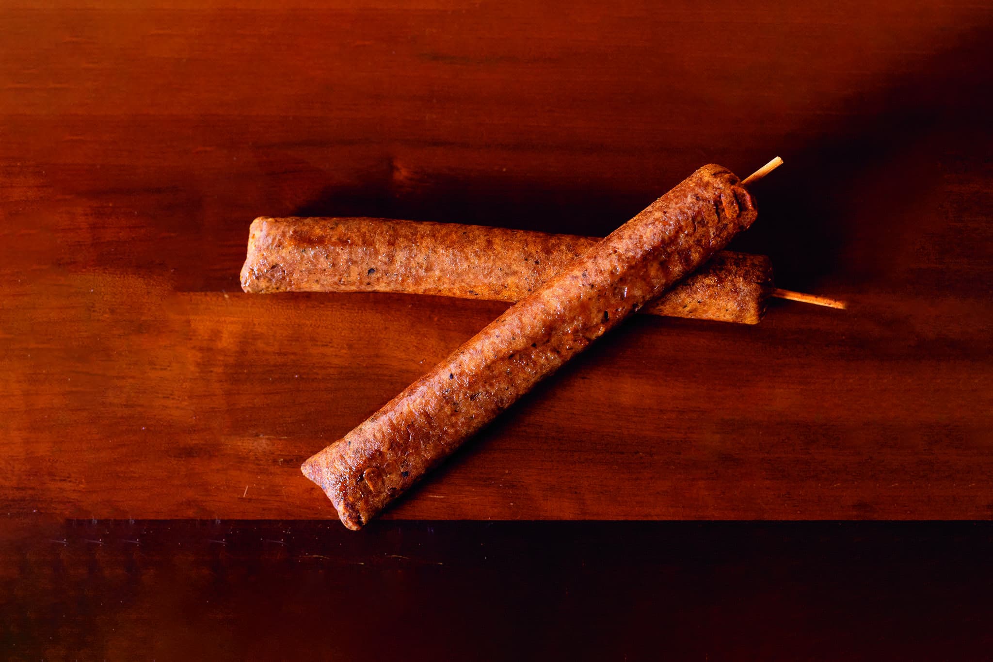 Espetos de kafta de soja grelhados sobre tábua de madeira